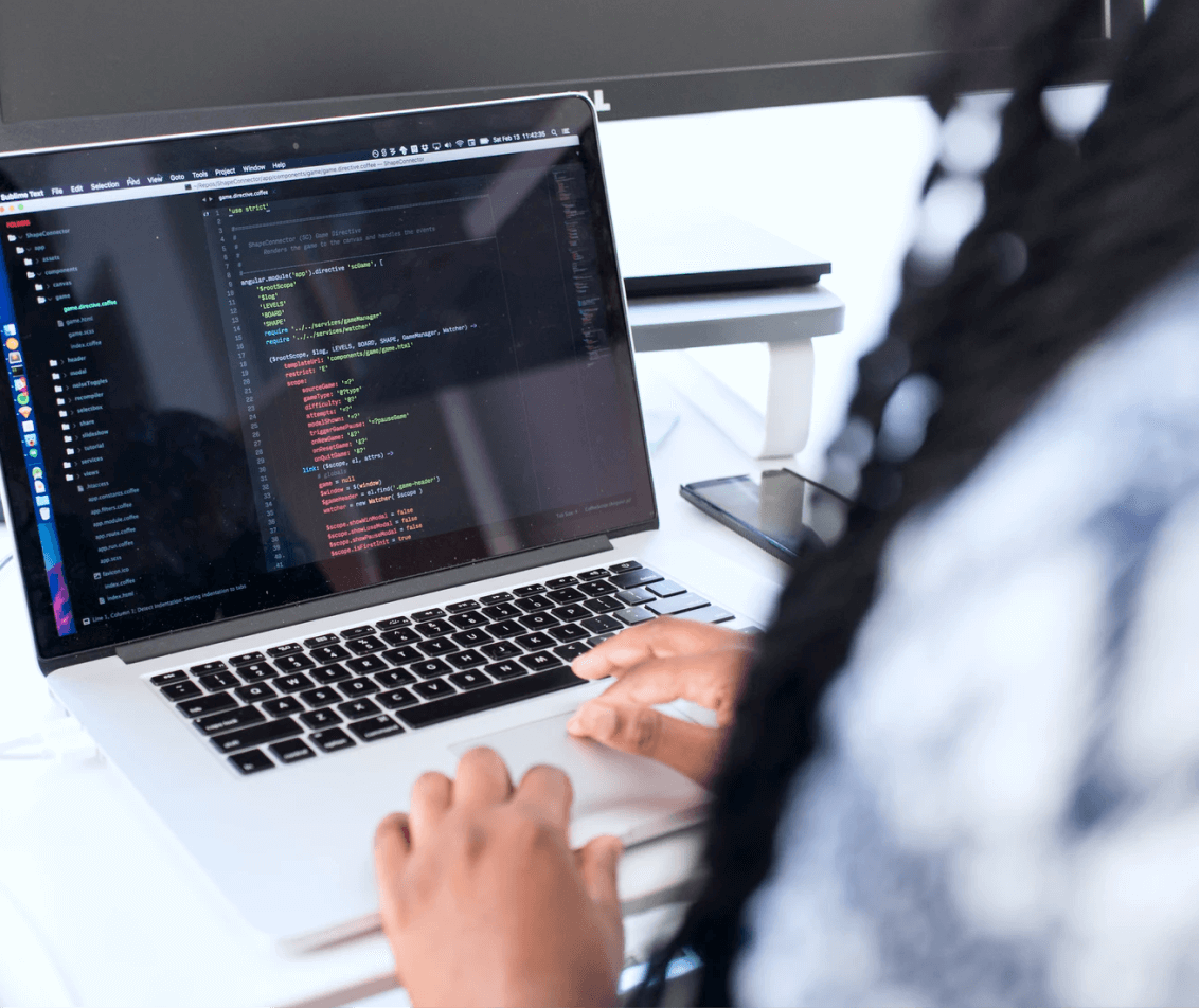 A woman writing code on her laptop