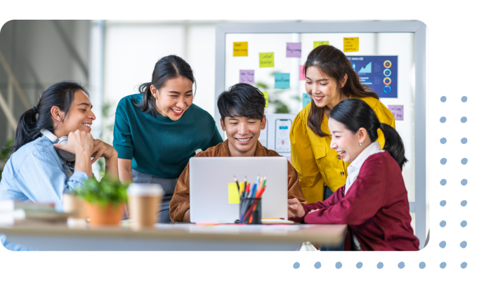 a group of people smiling and working on a laptop together